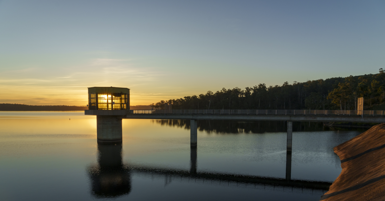 The sun sets behind Blue Rock Lake's outlet tower  