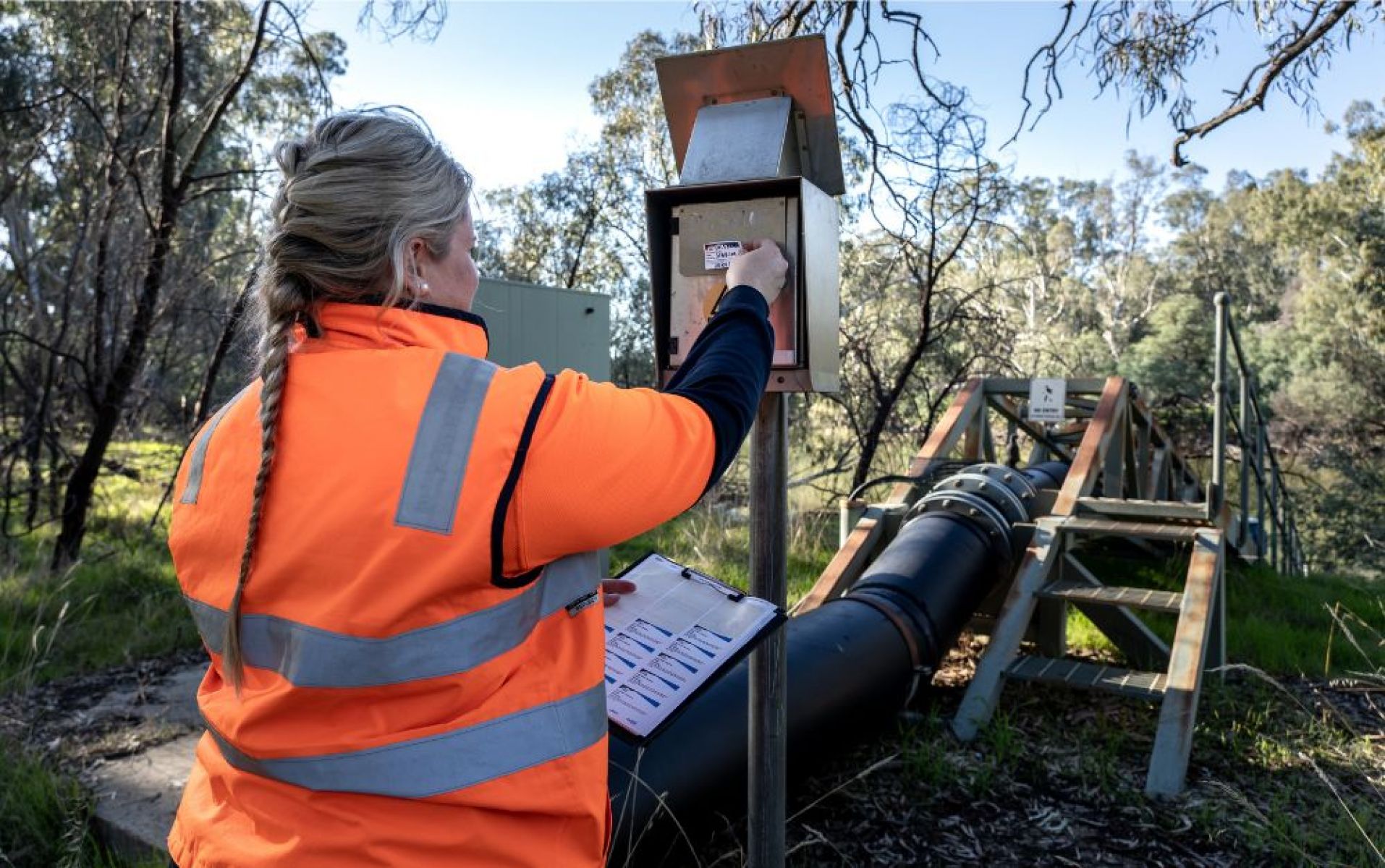 Photo of Water corporation field officer manually reading a non-urban water meter and telemetry device in northern Victoria.